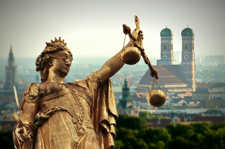 Justitia, im Hintergrund die Münchner Frauenkirche