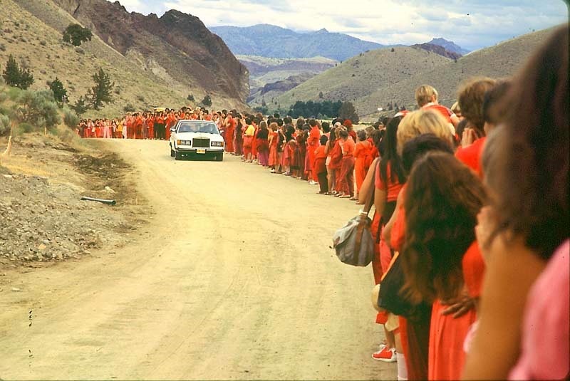 Bhagwan wird auf einem seiner täglichen "Drive-bys" von am Straßenrand auf ihn wartenden Sannyasins gegrüßt. Foto: ©&nbsp;Samvado Gunnar Kossatz, Wikipedia, gemeinfrei