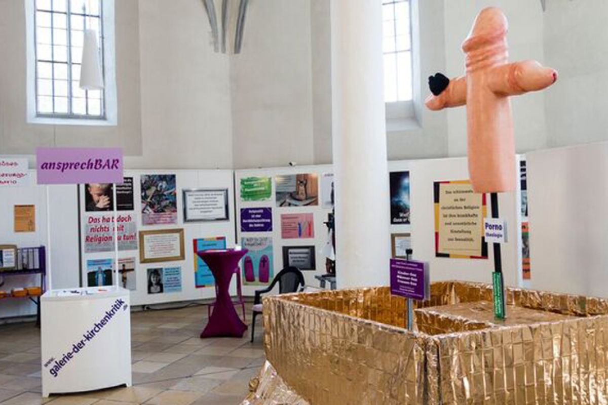 Anstelle des Altars: Der überdimensionierte Penis in Form eines christlichen Kreuzes