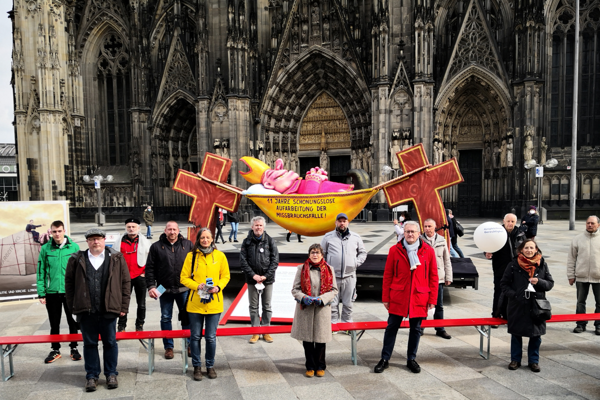 Mitglieder des "Aktionsbündnisses Betroffeneninitiativen" und Aktivistenvor dem Kölner Dom